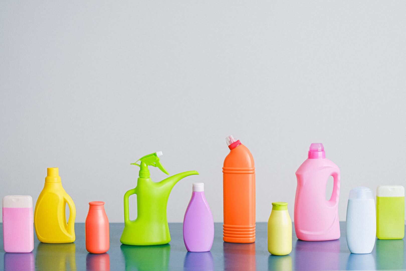A group of different colored bottles and jugs on top of a table.