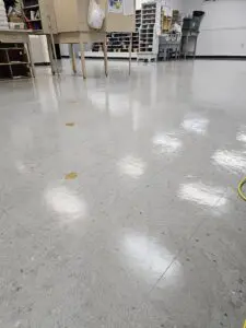 A white floor with yellow spots and brown stains.