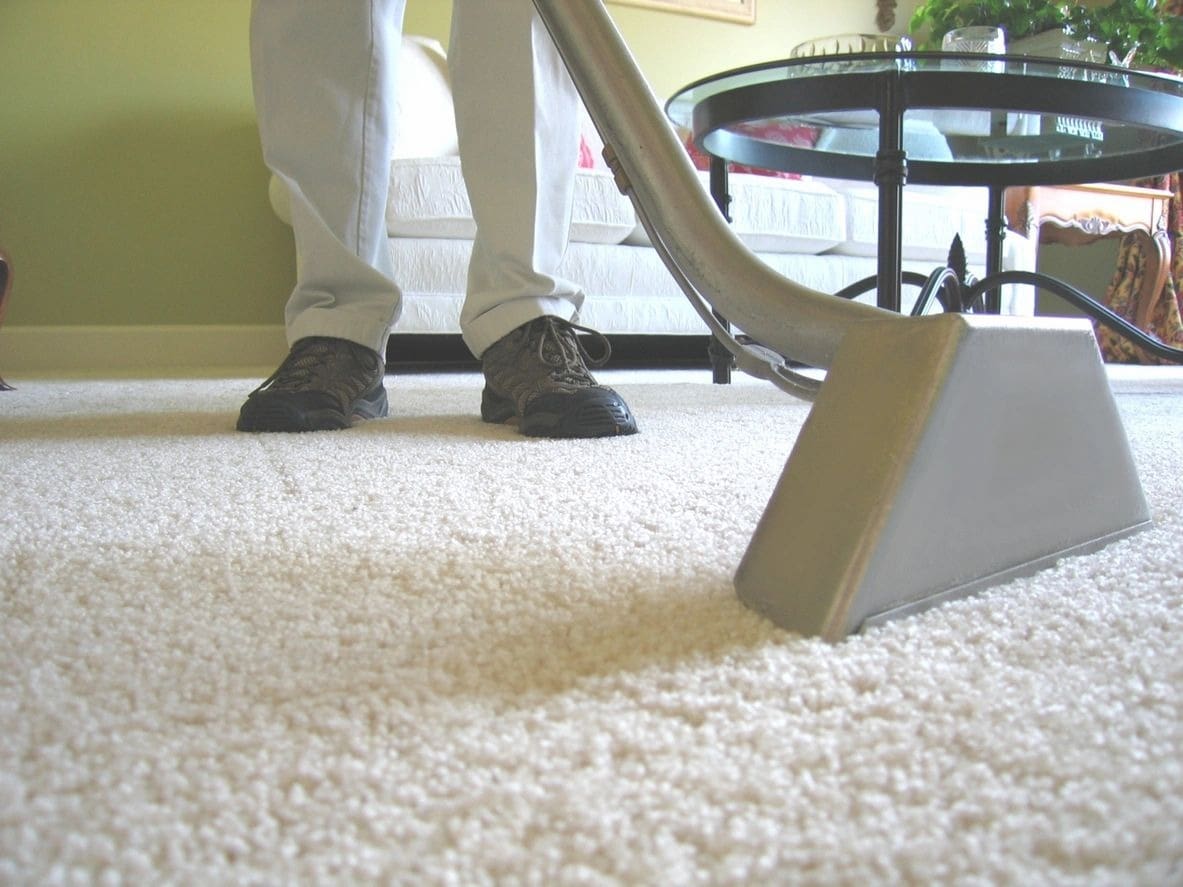 A person using a carpet cleaner on the floor